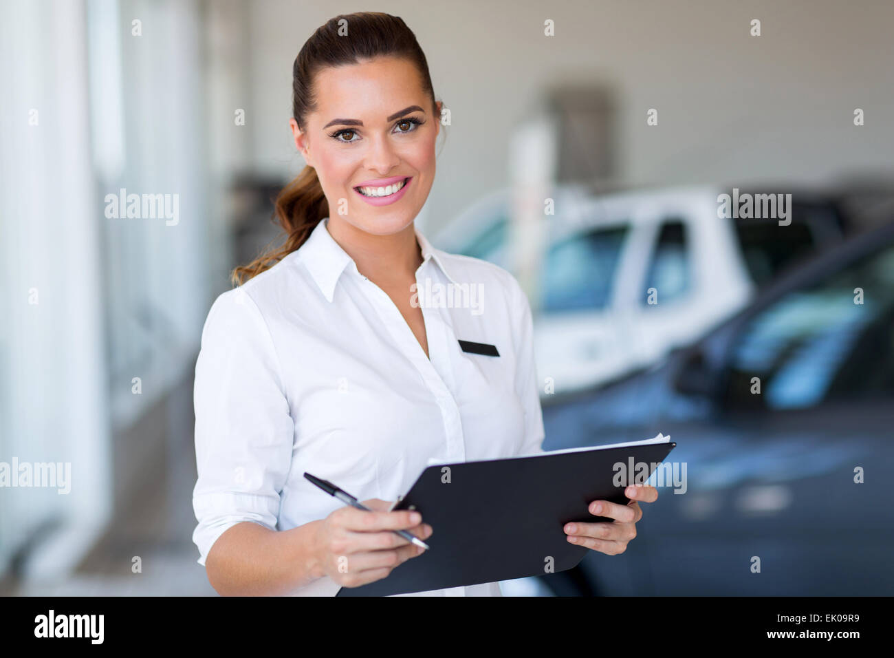 junge Auto Verkäuferin hält Zwischenablage im showroom Stockfoto