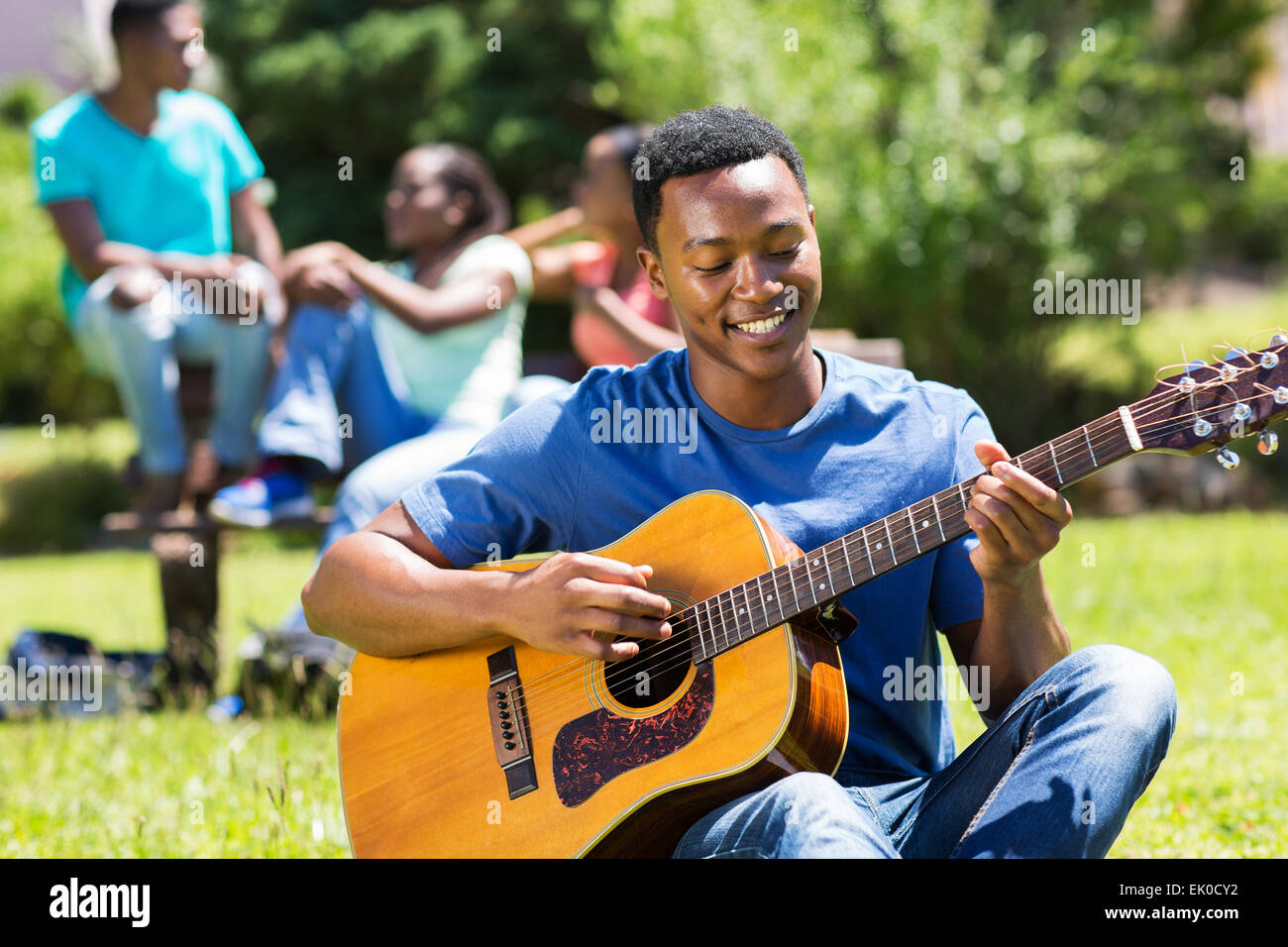 glückliche junge afrikanische amerikanische College Boy Gitarre auf dem campus Stockfoto