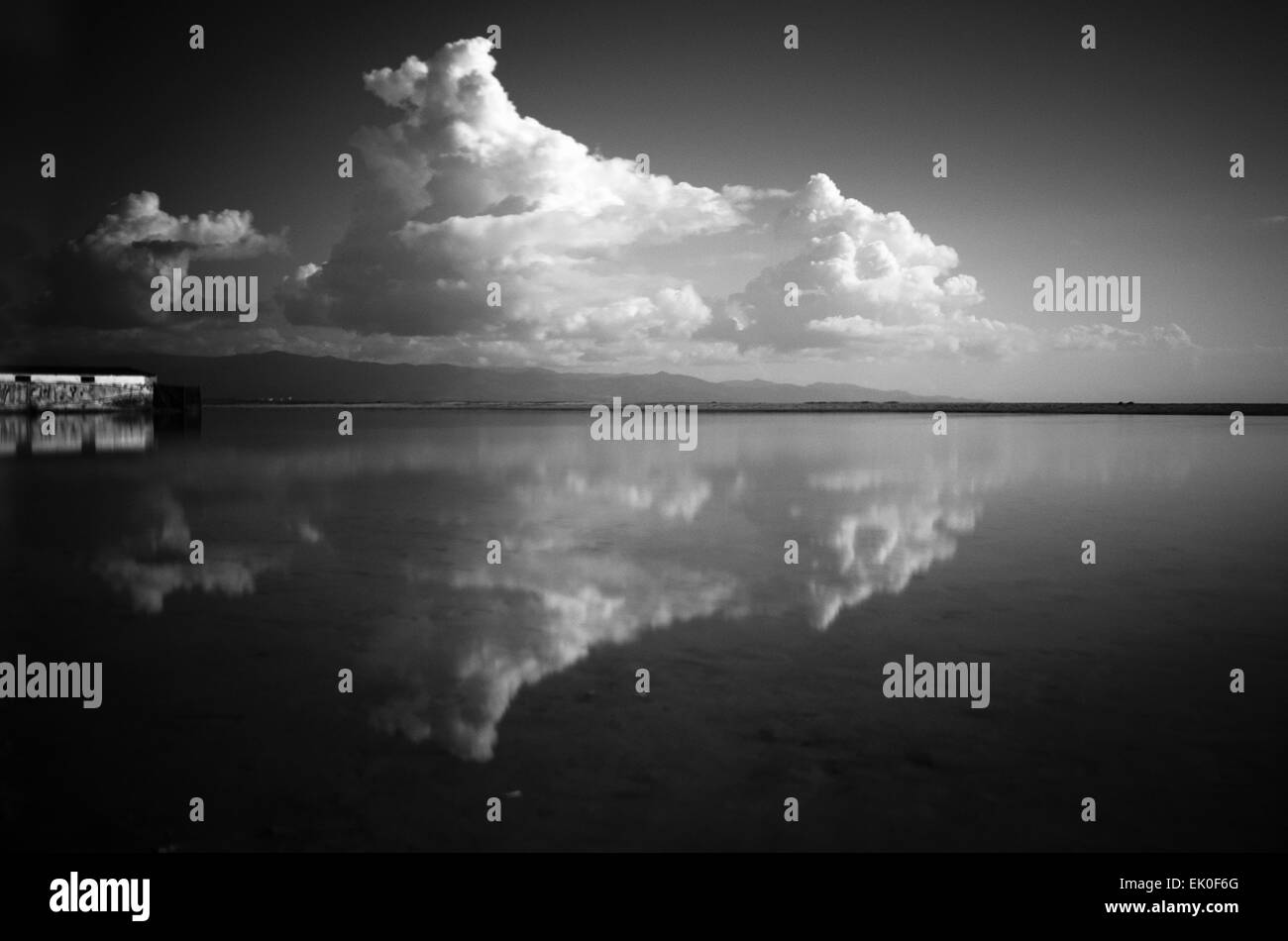 Schwarz / weiß-Landschaft an der Küste mit Wolken und Reflexion als Hintergrund Stockfoto