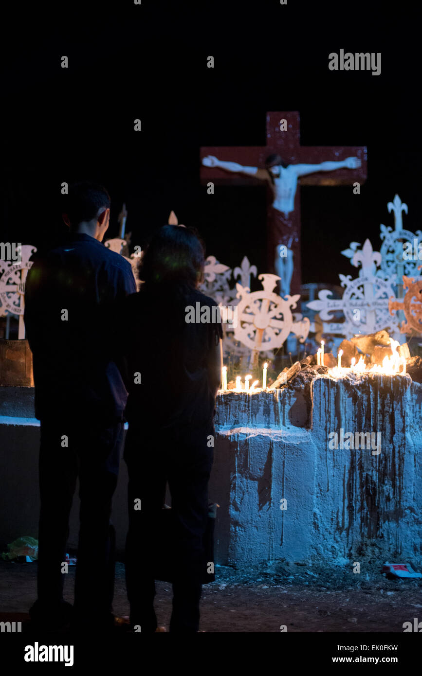 Ein junges Paar betet auf katholischen Friedhof in Larantuka, Insel Flores, Indonesien, nach mass Zeremonie in der Kathedrale-Kirche. Tausende von Menschen, darunter auch aus anderen Städten und Ländern, besuchen eine ganze Woche Zeremonien zur Feier der Karwoche in der kleinen Stadt Larantuka, eines der einflussreichsten Städte in Indonesien in Bezug auf die katholischen Traditionen. Stockfoto