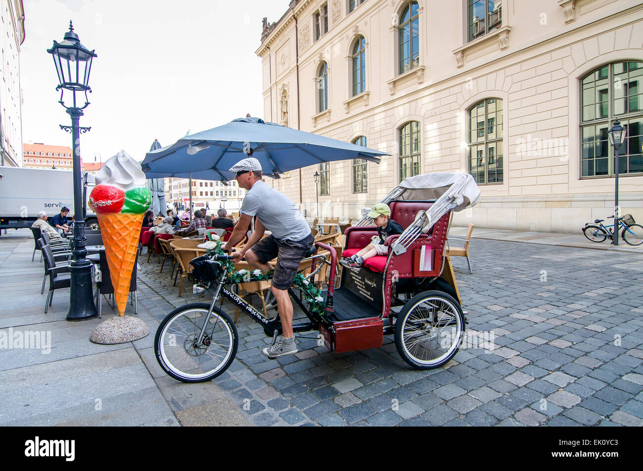 Fahrrad-Taxi-Fahrer-Haltestellen mit seinem kleinen Sohn für ein Eis brechen in Dresden, Deutschland. Stockfoto