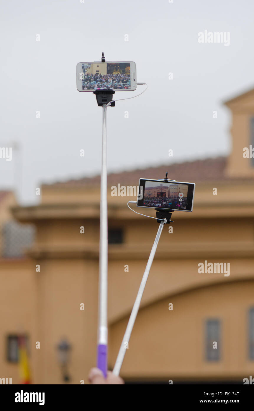 Zwei Selfie-Sticks oder Einbeinstative verwendet, um ein Ereignis zu erfassen. Spanien Stockfoto