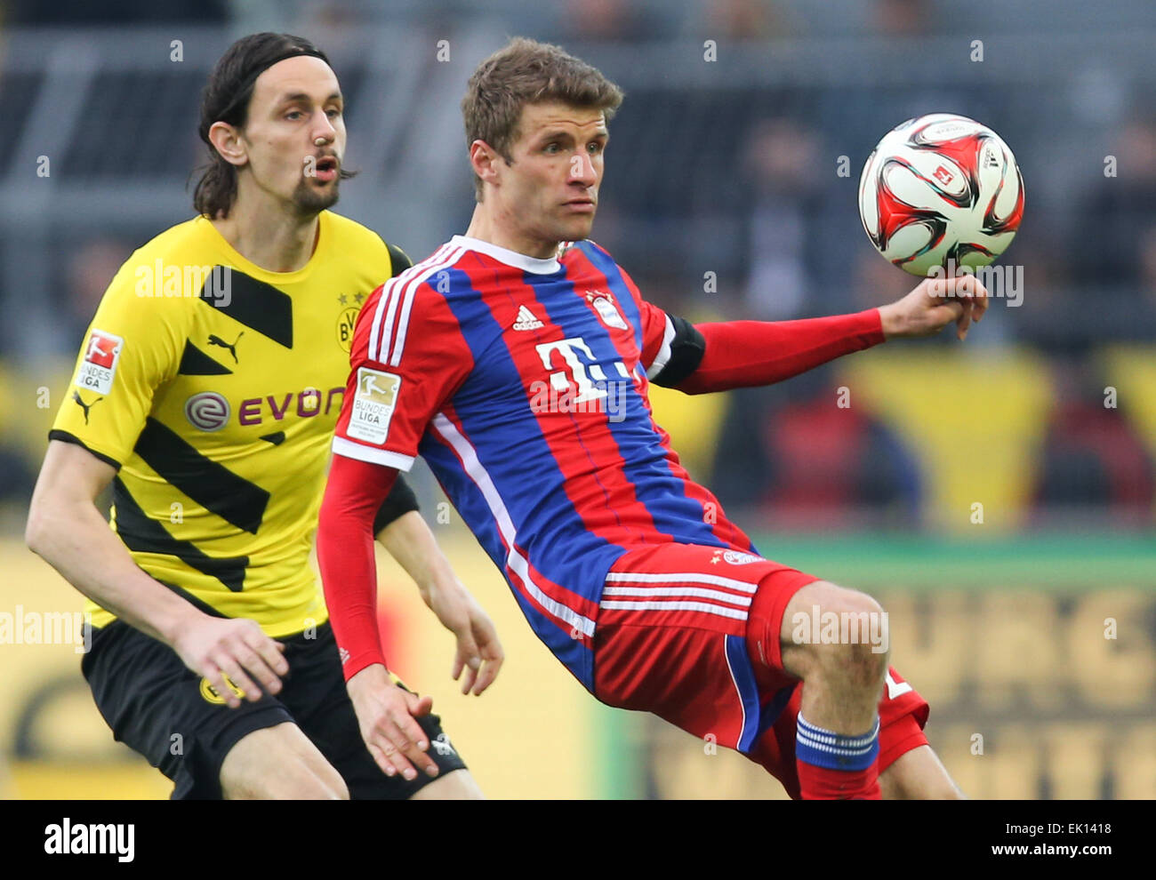 Dortmund, Deutschland. 4. April 2015. Dortmunds Neven Subotic (l) und Münchens Thomas Mueller (r) kämpfen um den Ball in der deutschen Bundesliga-Fußballspiel zwischen Borussia Dortmund und Bayern München im Signal-Iduna-Park in Dortmund, Deutschland, 4. April 2015. Foto: FRISO GENTSCH/Dpa EMBARGO Bedingungen - Achtung: aufgrund der Akkreditierungsrichtlinien die DFL nur erlaubt die Veröffentlichung und Nutzung von bis zu 15 Bilder pro Spiel im Internet und in Online-Medien während des Spiels.) Bildnachweis: Dpa/Alamy Live-Nachrichten Stockfoto