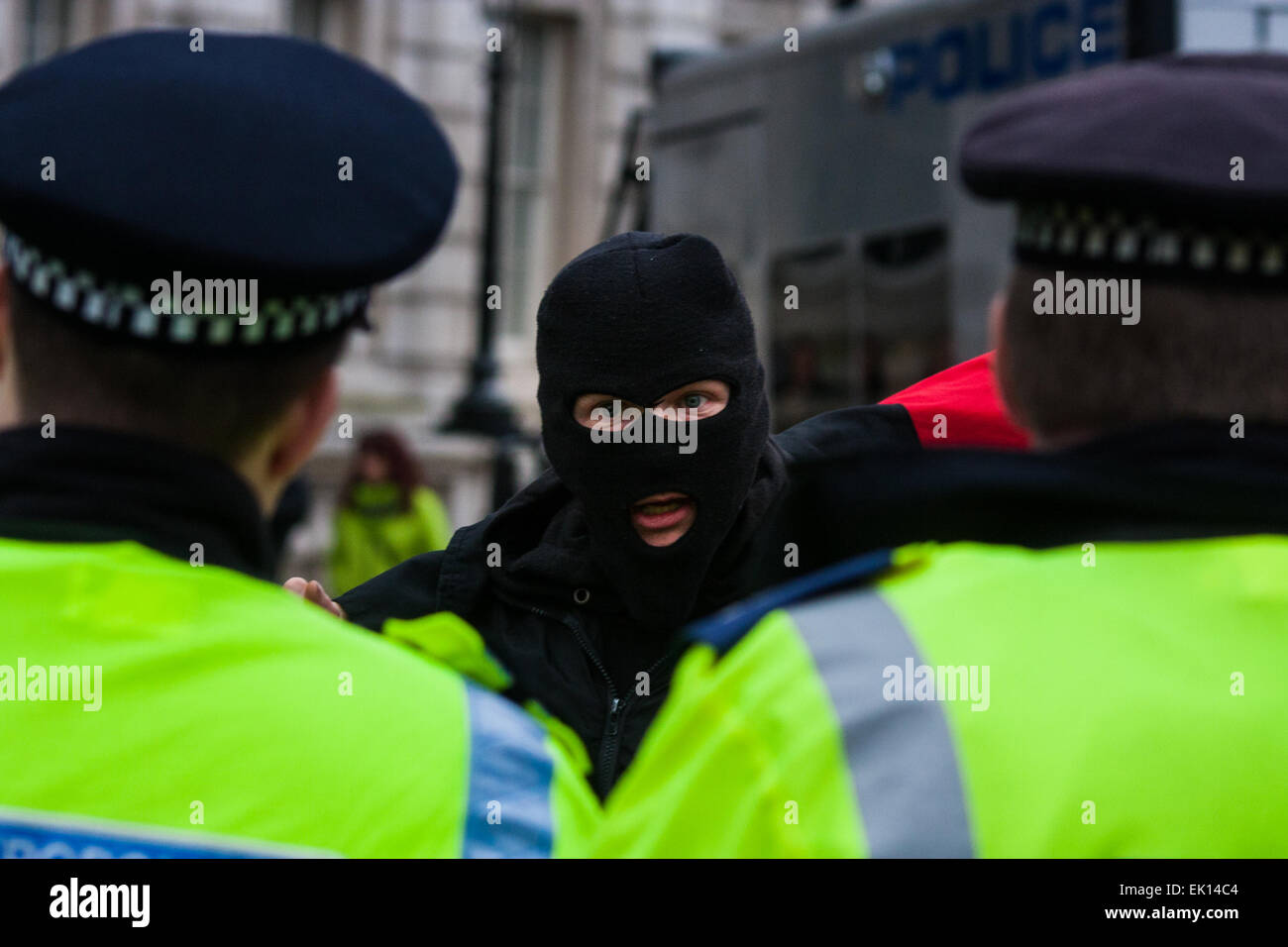 Whitehall, London, 4. April 2015. Wie PEGIDA UK eine schlecht besuchte Kundgebung am Whitehall hält, sind Resultate von Polizei gerufen, um gegen Demonstranten aus verschiedenen London antifaschistischen Bewegungen enthalten. Bild: Ein maskierter antifaschistischen Counter Demonstrant verspottet Polizisten Credit: Paul Davey/Alamy Live News Stockfoto