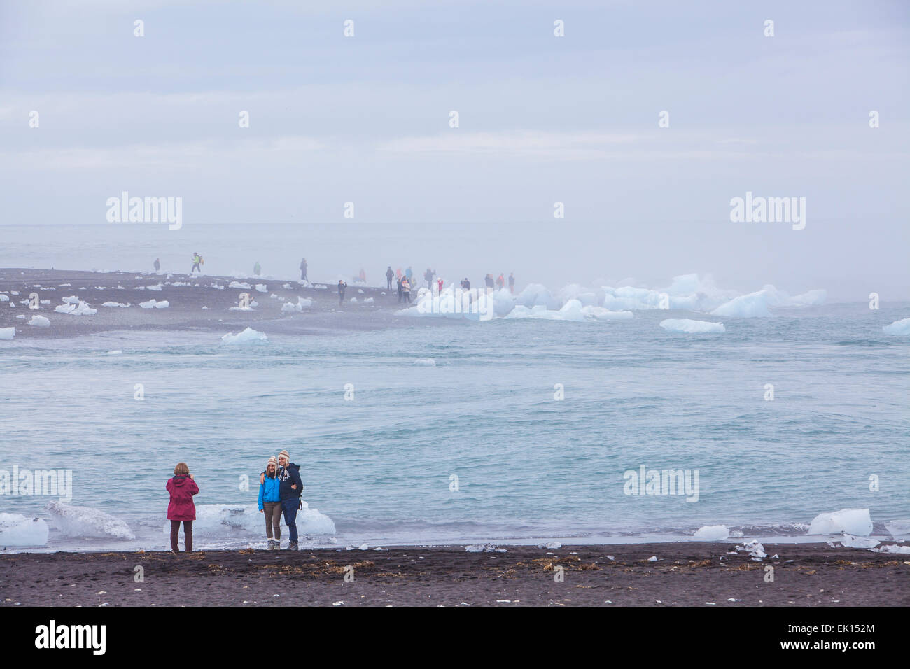 Blick auf Menschen, die die Fotos durch den Ozean mit Eisberge in der Nähe der Gletscherlagune Jökulsárlón im Süden Islands Stockfoto