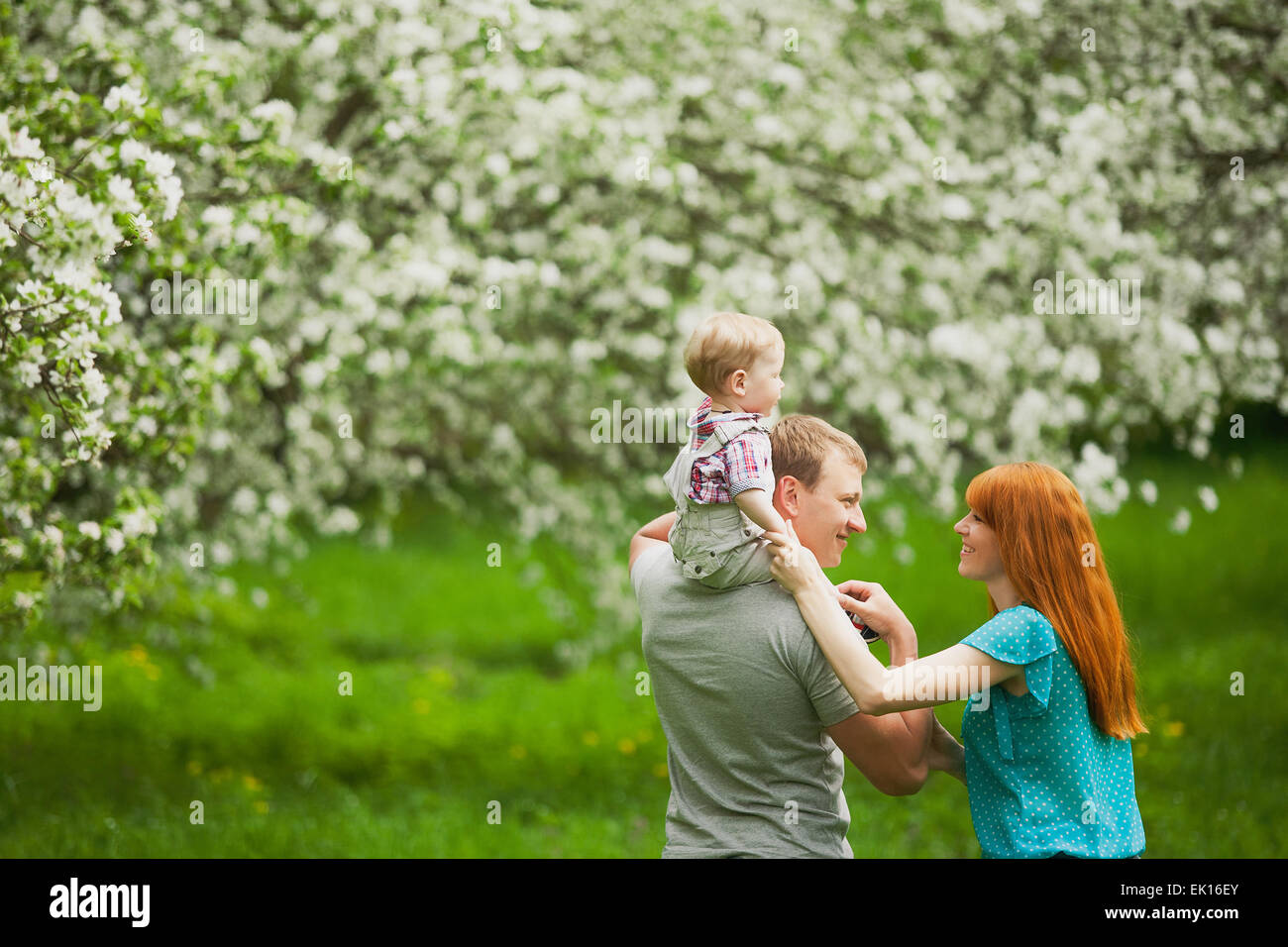 Glückliche Familie Spaß im Freien im Frühlingsgarten. Vater, Mutter und Kind. Familienkonzept Stockfoto