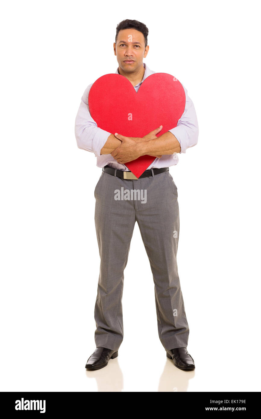 Mann mittleren Alters umarmt rotes Herzform isoliert auf weißem Hintergrund Stockfoto