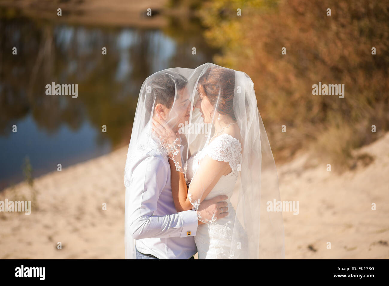 Braut und Bräutigam küssen am Strand, romantische Ehepaar Stockfoto