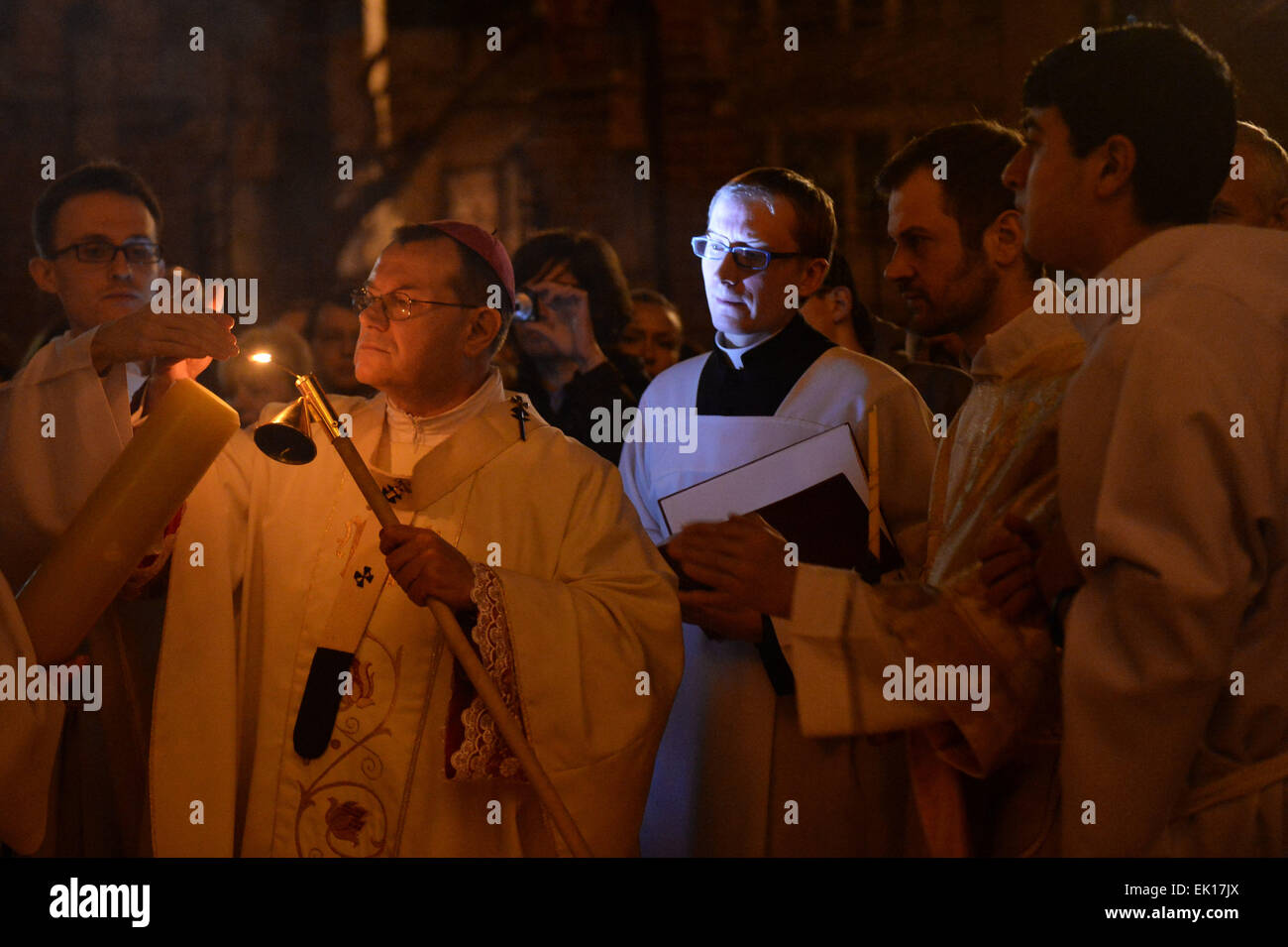 Moskau, Russland. 4. April 2015. Erzbischof Paolo Pezzi (2. L) leuchtet das Osterfeuer auf dem Pashal Kerze während der Ostergottesdienst in der Kathedrale der Unbefleckten Empfängnis in Moskau, Russland, 4. April 2015. © Pavel Bednyakov/Xinhua/Alamy Live-Nachrichten Stockfoto