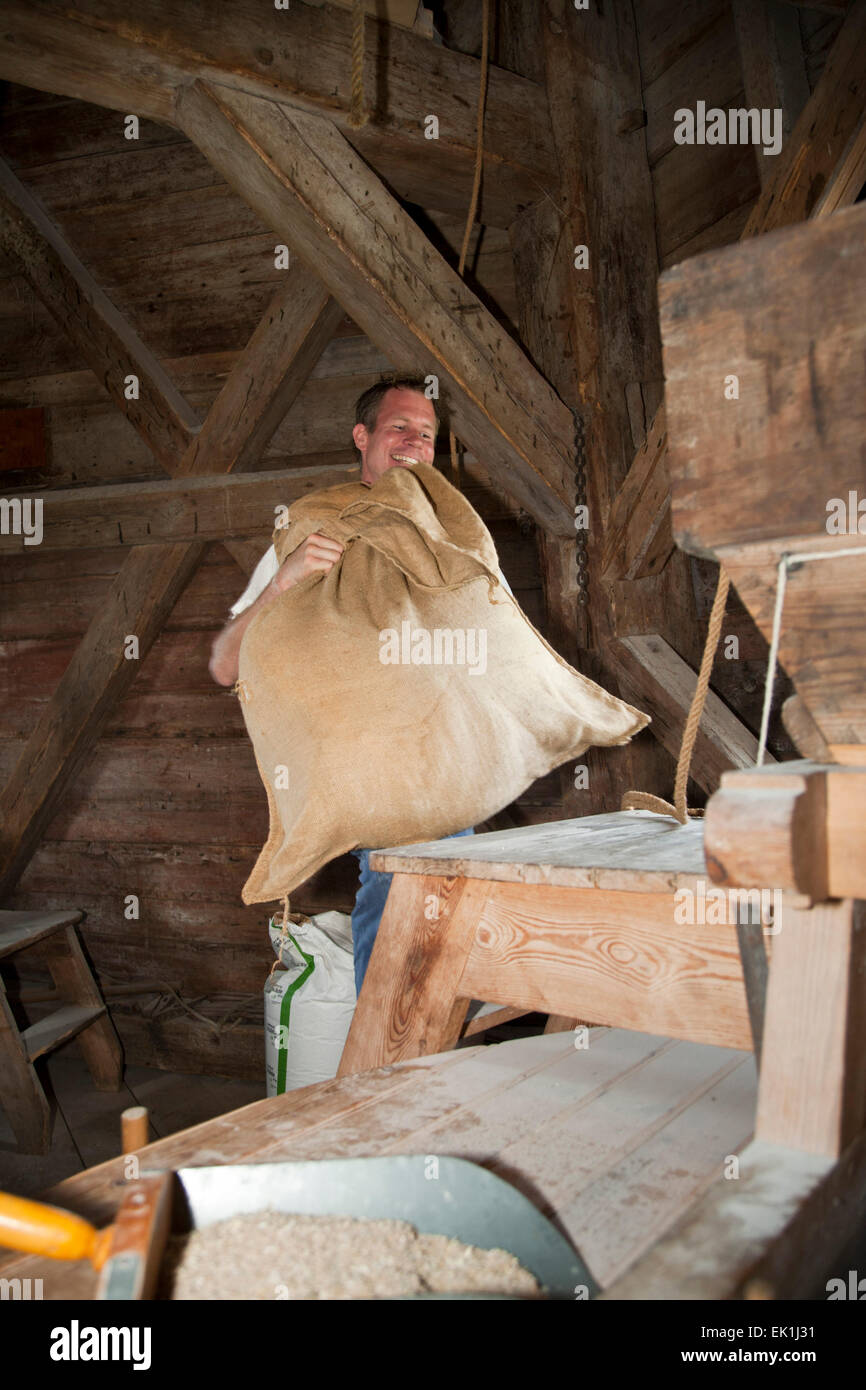 Ein Mann Tragetaschen mit Mehl in einer Mühle Stockfoto