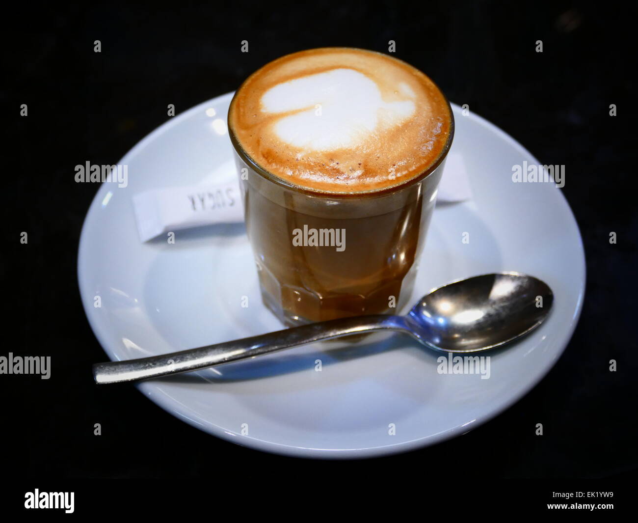 Spanien-Kanarische Inseln Teneriffa Kaffee Espresso mit Milch Zucker Päckchen Löffel auf die Untertasse Stockfoto