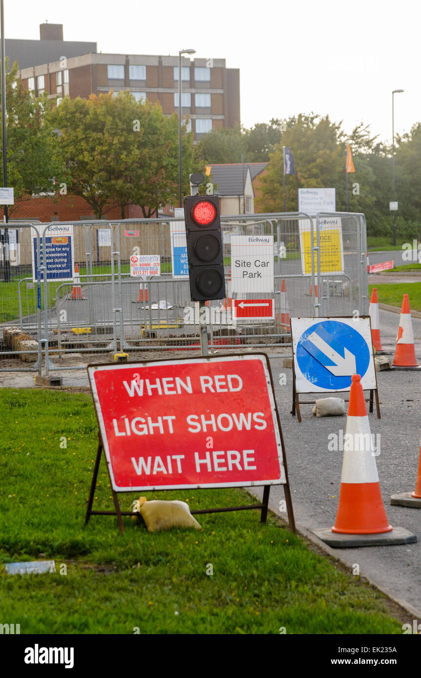 Baustellen mit roten Ampeln und ein Schild mit der Aufschrift "Wenn rotes Licht zeigt hier warten" Stockfoto