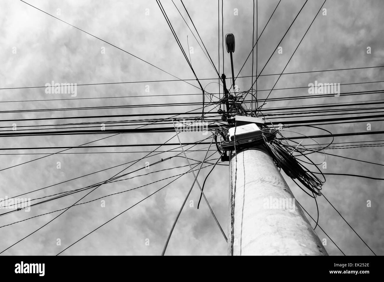 Eine Straße Laternenpfahl mit vielen elektrischen Leitungen, die in verschiedene Richtungen laufen. Stockfoto