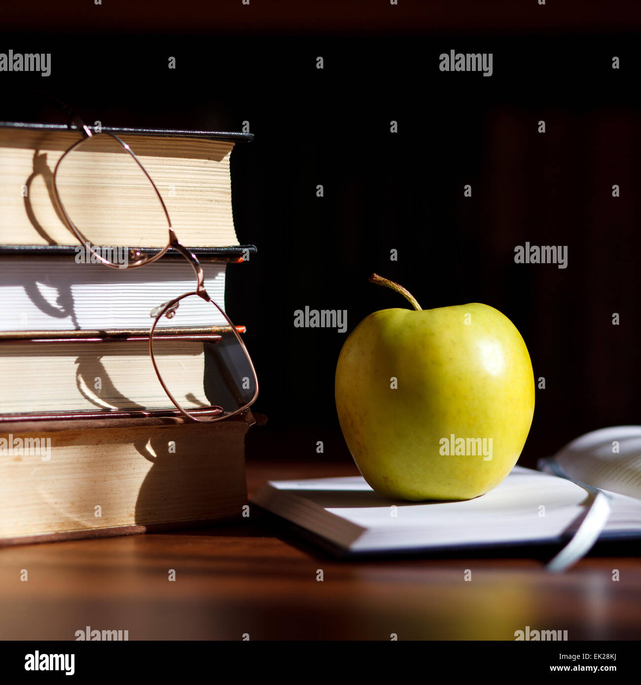 Grüner Apfel auf das aufgeschlagene Buch Stockfoto