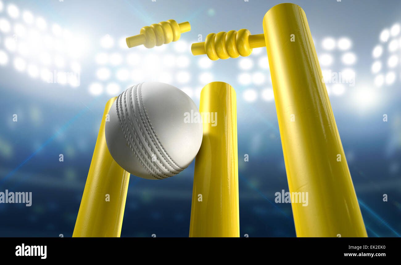 Ein weißes Leder Cricketball schlagen gelb Holz Cricket Wickets auf einem Hintergrund beleuchtete Stadion bei Nacht Stockfoto