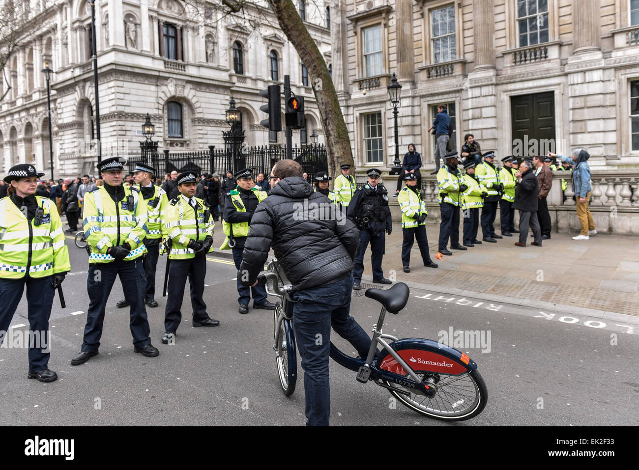 Ein Radfahrer, der Versuch, durch eine Polizeikette in Whitehall zu fahren. Stockfoto