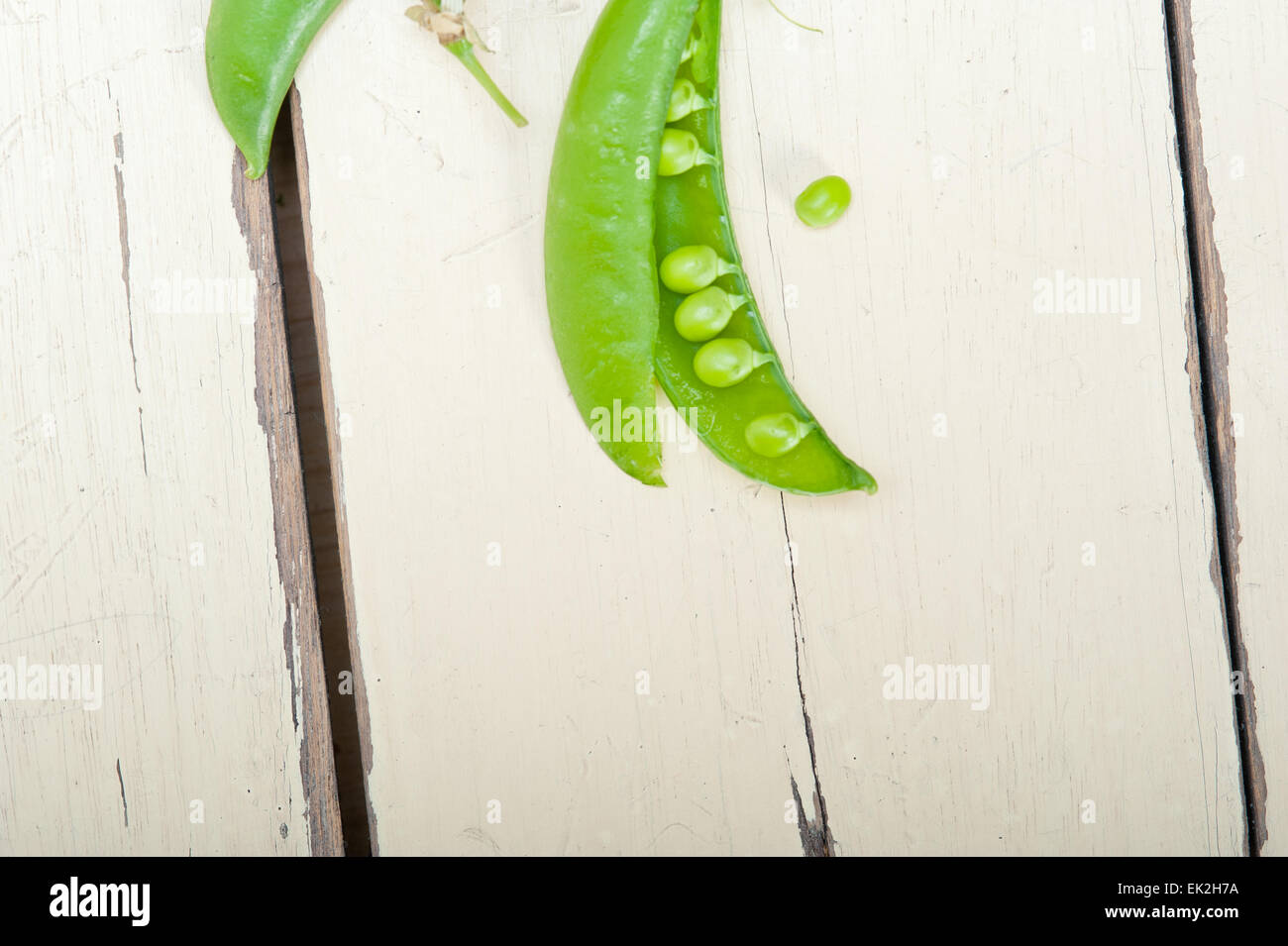 hearthy frische grüne Erbsen über einen rustikalen Holztisch Stockfoto