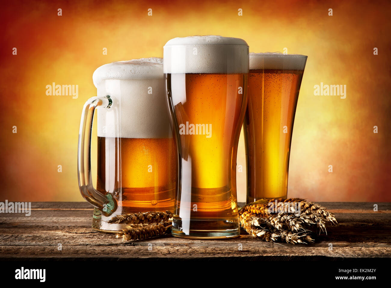 Drei Bier und Weizen auf gelbem Hintergrund Stockfoto