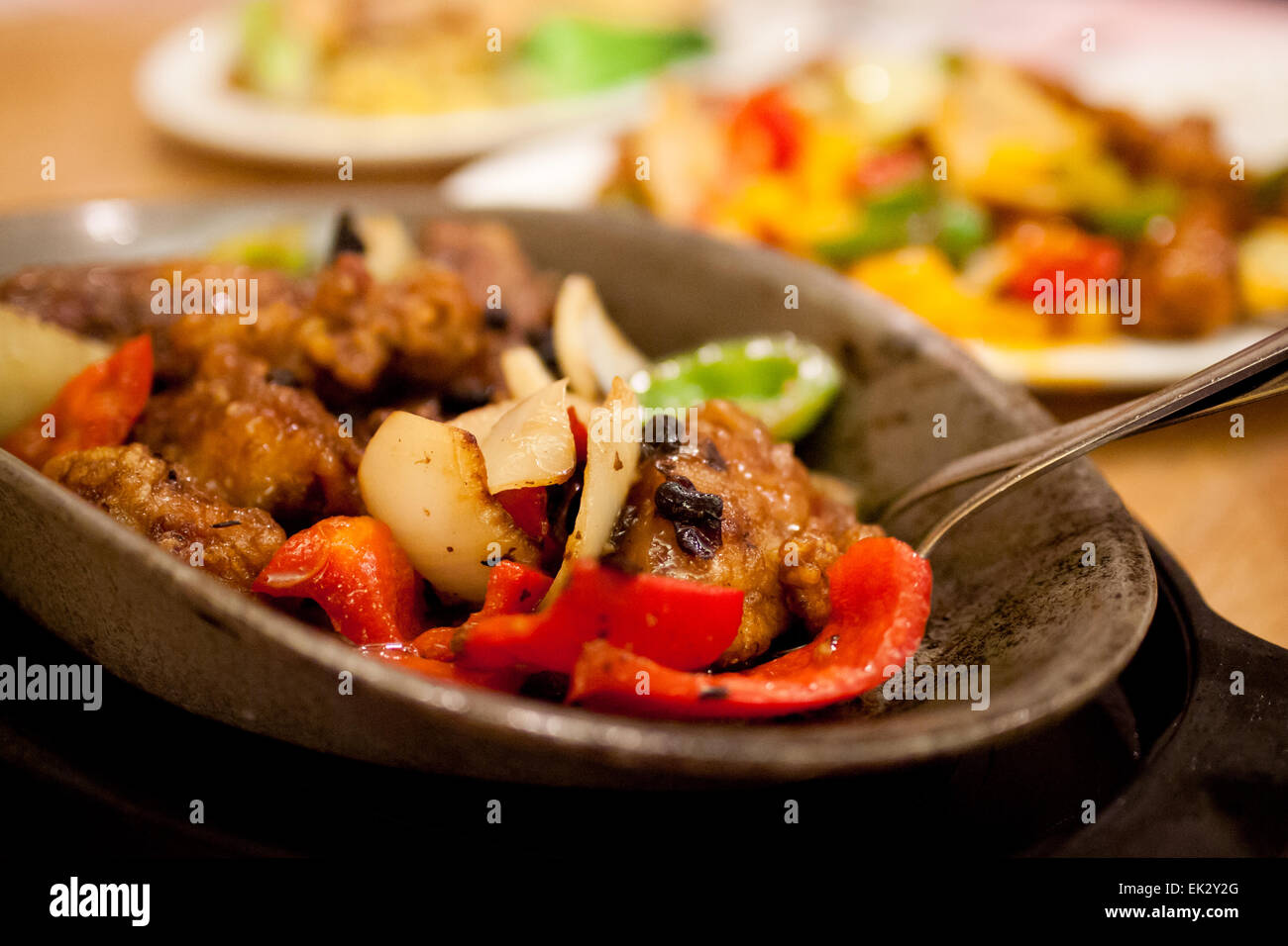 Chinesisches Essen: Rühren braten Huhn und Gemüse in schwarzen Bohnensauce, serviert auf einer heißen, Guss Eisenplatte. Stockfoto