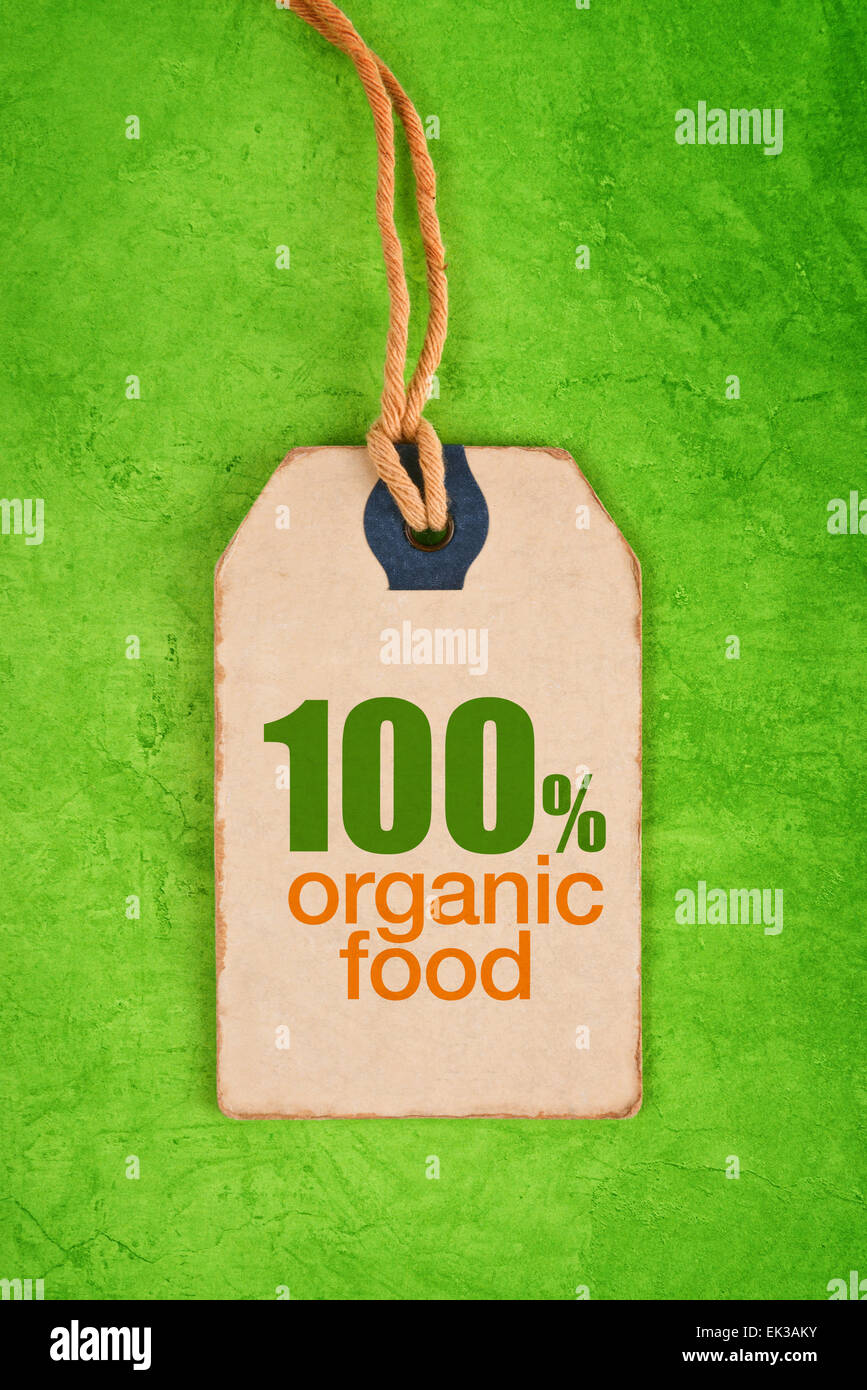 100 Prozent Bio-Lebensmittel auf Vintage Label Tag Preisschild auf grüne Grunge strukturierten Hintergrund, Ansicht von oben. Stockfoto