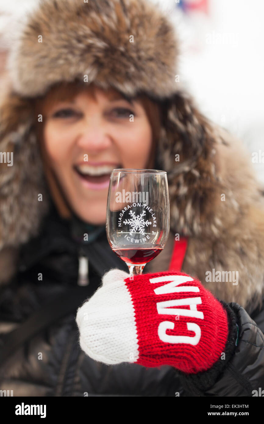 Kanada, Ontario, Niagara-on-the-Lake, Eiswein Festival, Frau gekleidet für den Winter mit Glas Eiswein Stockfoto