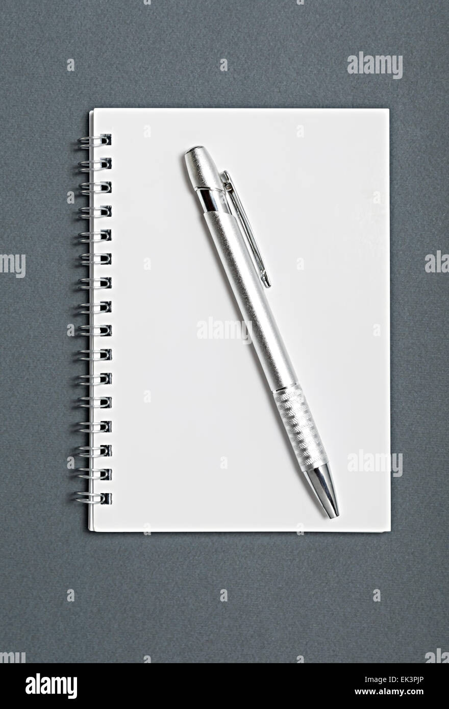 Bleistift auf einem Notebook auf grauem Hintergrund isoliert. Stockfoto