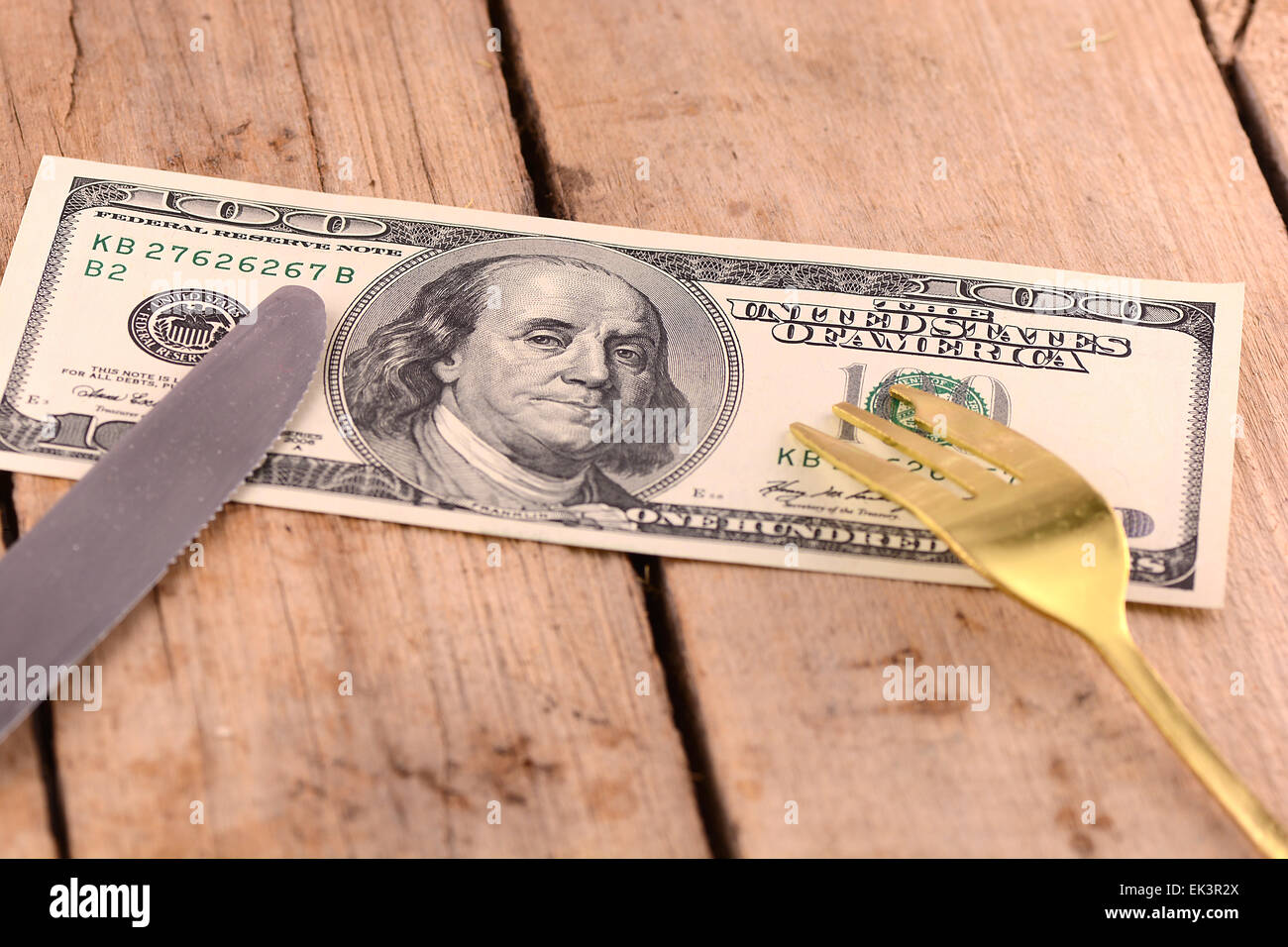 amerikanisches Geld auf Holzteller mit Messer und fok Stockfoto