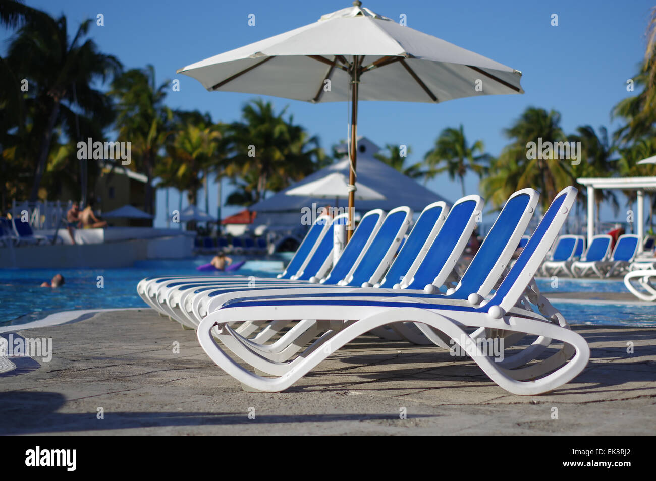 Lounge Stühle um einen Pool in einem tropischen resort Stockfoto