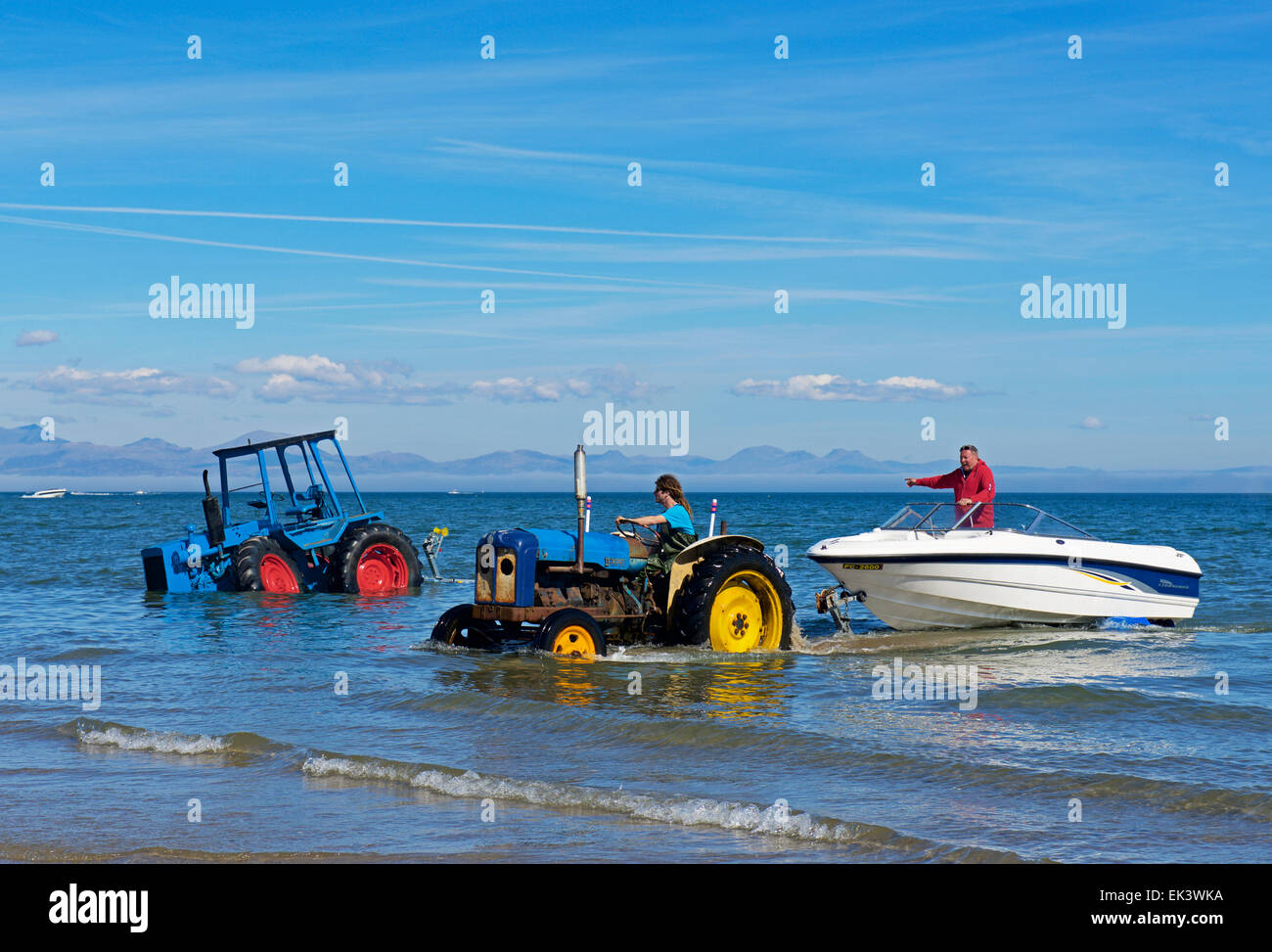 Traktor zieht mit dem Schnellboot auf Anhänger aus Meer, Abersoch, LLyn Peninsular, Gwynedd, North Wales, UK Stockfoto