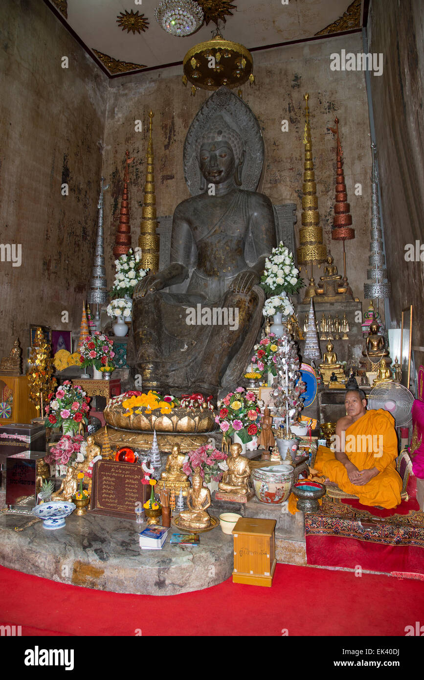 Buddhistischer Mönch sitzt im Wat Na Phra Mane Tempel von Ayutthaya Thailand trägt die traditionelle Orange gefärbte Gewand Stockfoto
