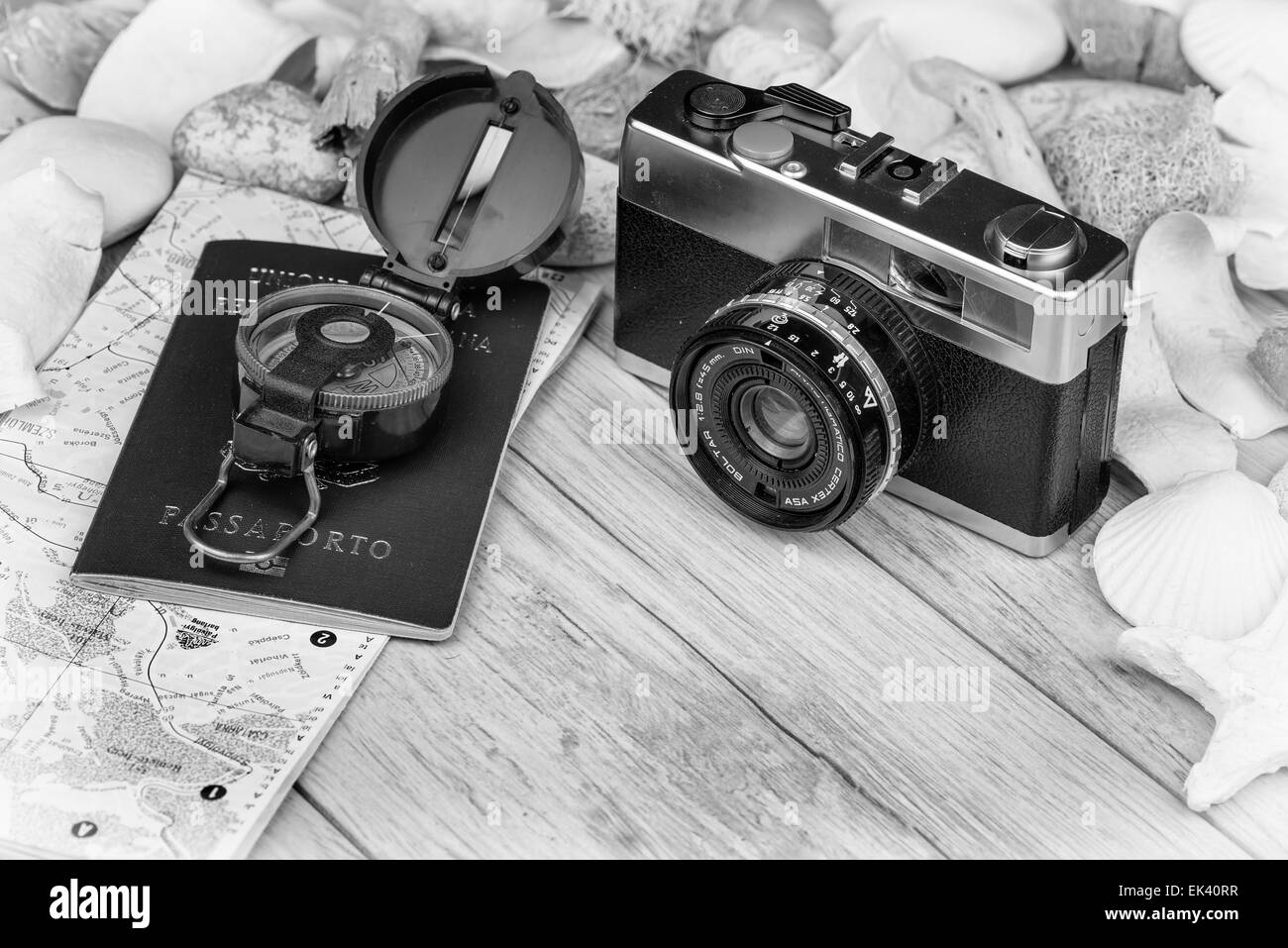 Im Bild eine analoge Kamera Film, einen Kompass, Passaport und eine Karte, auf den Seiten Muscheln und dekorativen Steinen. Stockfoto