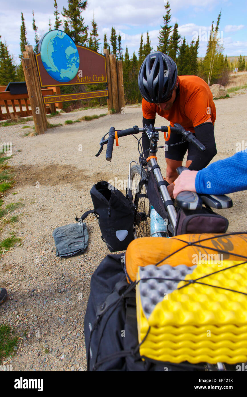 Radfahrer hält am Polarkreis auf dem Dalton Highway, Alaska. Stockfoto