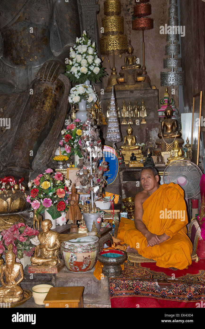 Buddhistischer Mönch sitzt im Wat Na Phra Mane Tempel von Ayutthaya Thailand trägt die traditionelle Orange gefärbte Gewand Stockfoto