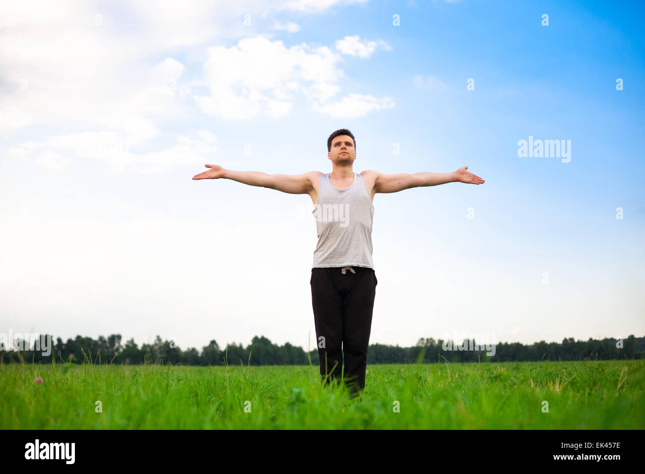 Junger Mann beim Yoga im park Stockfoto