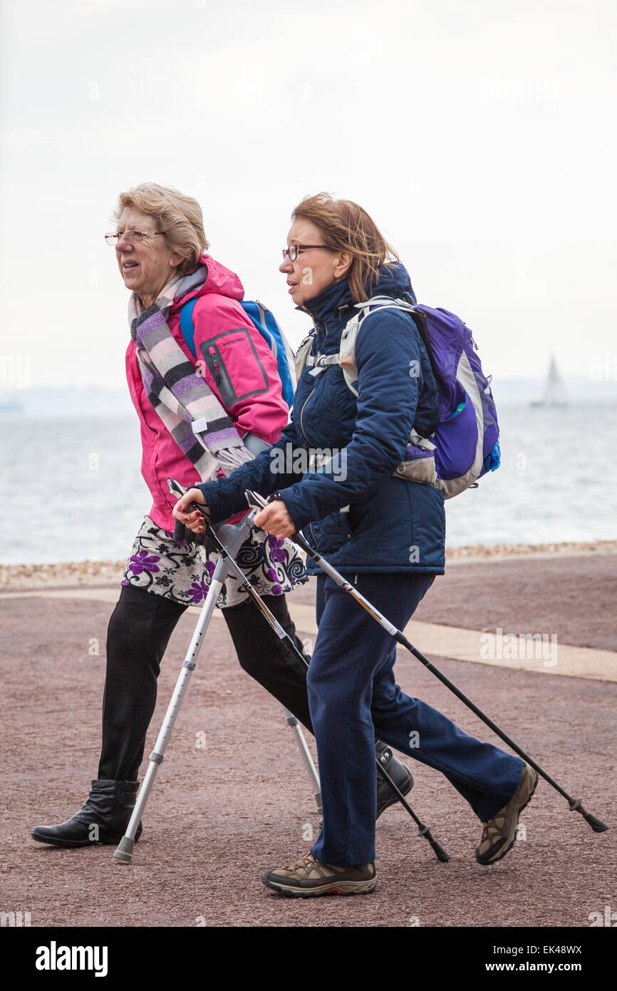 Zwei Damen, die zu Fuß entlang der Promenade in Southsea, Portsmouth, UK Stockfoto