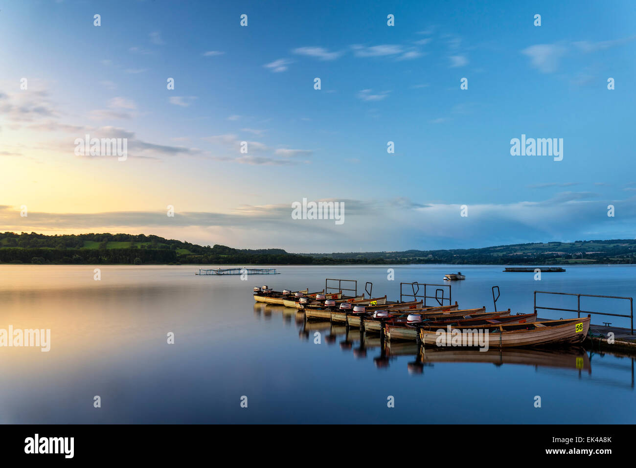 Landschaft-Sonnenaufgang über dem noch See mit Booten auf Steg Stockfoto