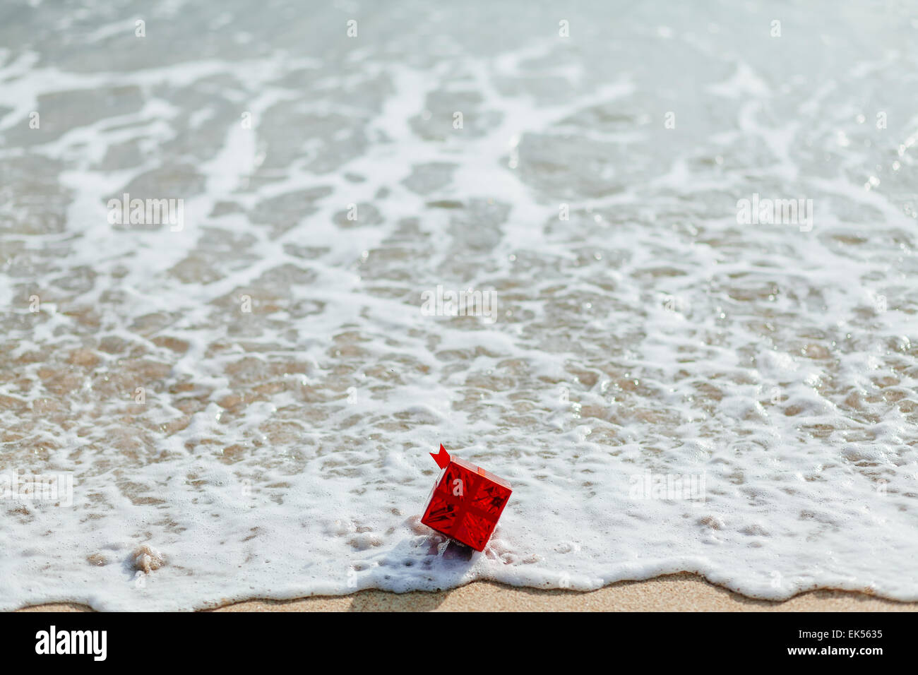 roten Geschenkbox am Strand mit Meerblick Stockfoto