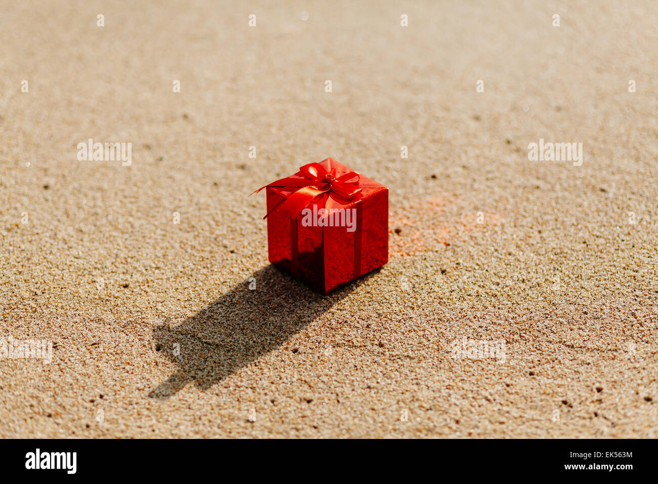 roten Geschenkbox am Strand mit Meerblick Stockfoto