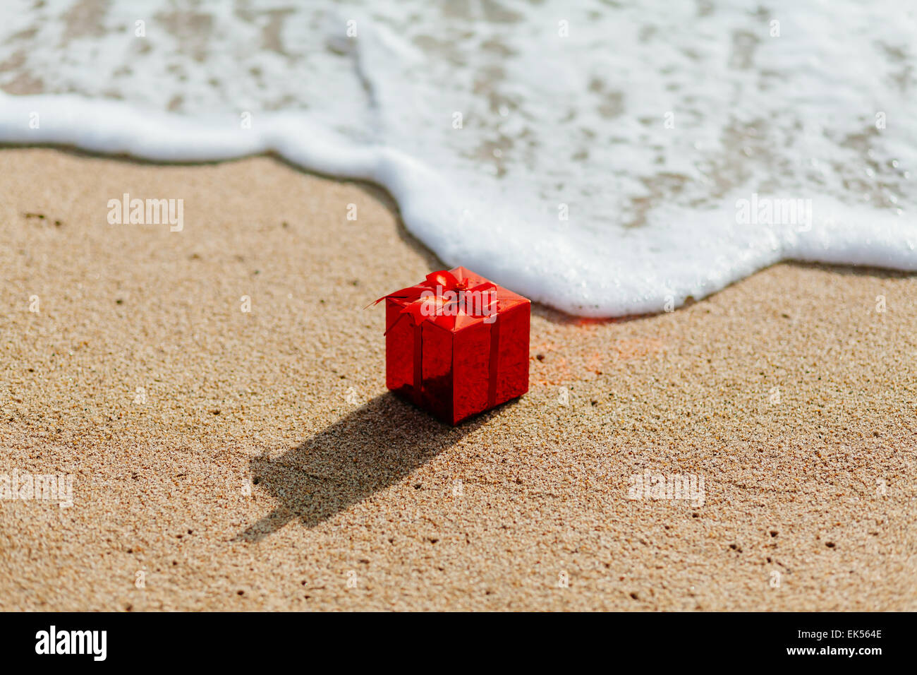 roten Geschenkbox am Strand mit Meerblick Stockfoto