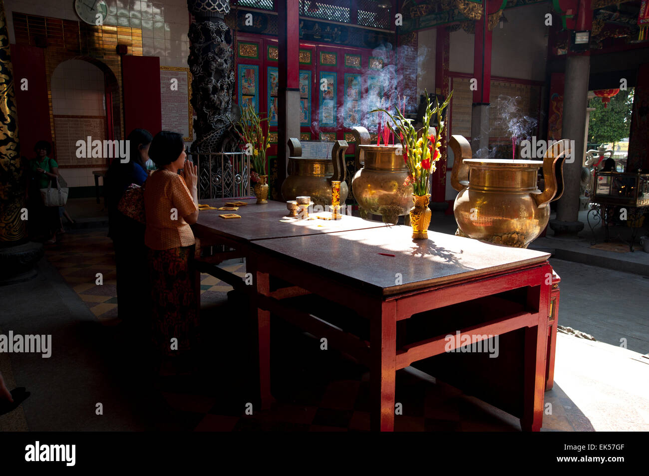 Chinesische Gläubige beten in den stimmungsvollen Schatten auf dem Altar eines chinesischen Tempels in Yangon Myanmar Stockfoto