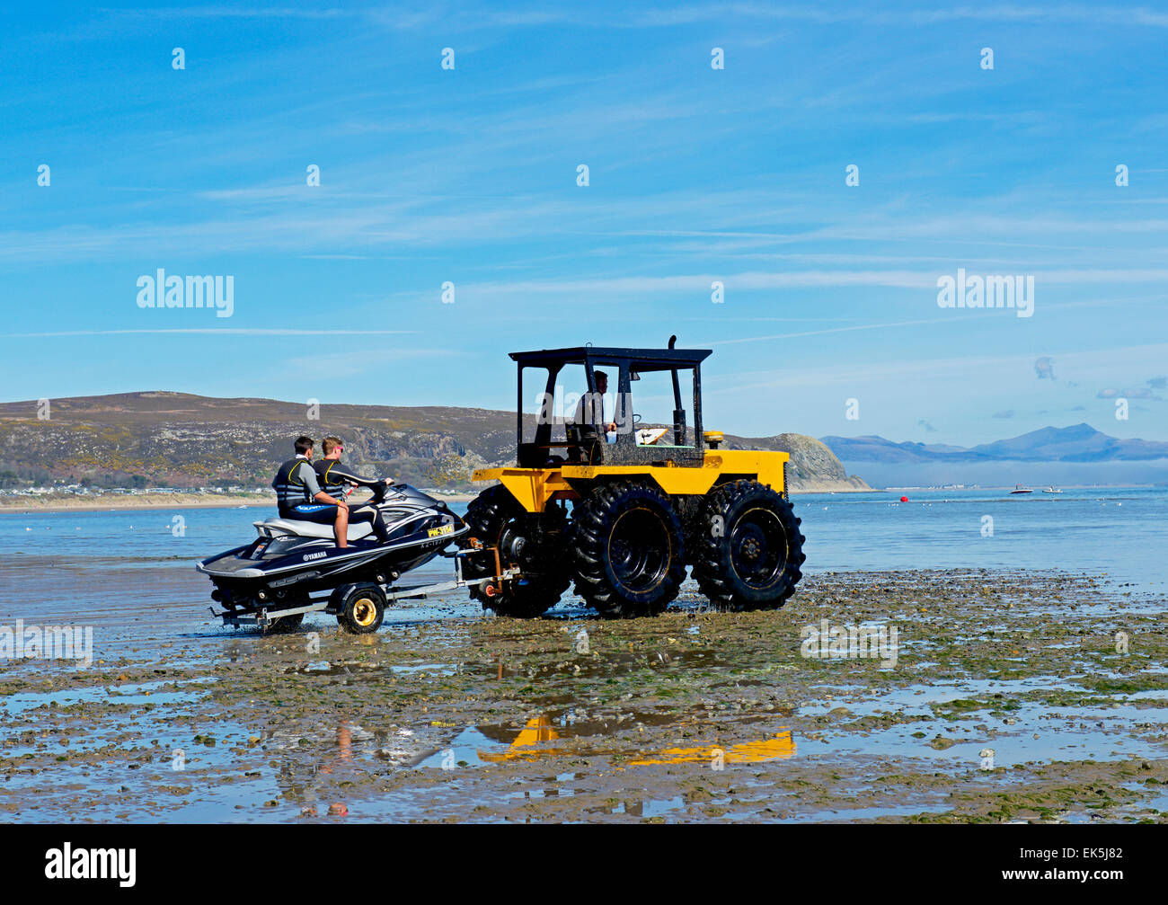 Drei Jugendliche auf Jetski ins Meer bei Abersoch, Llyn Peninsular, Gwynedd, North Wales UK Abschleppen Traktor Stockfoto