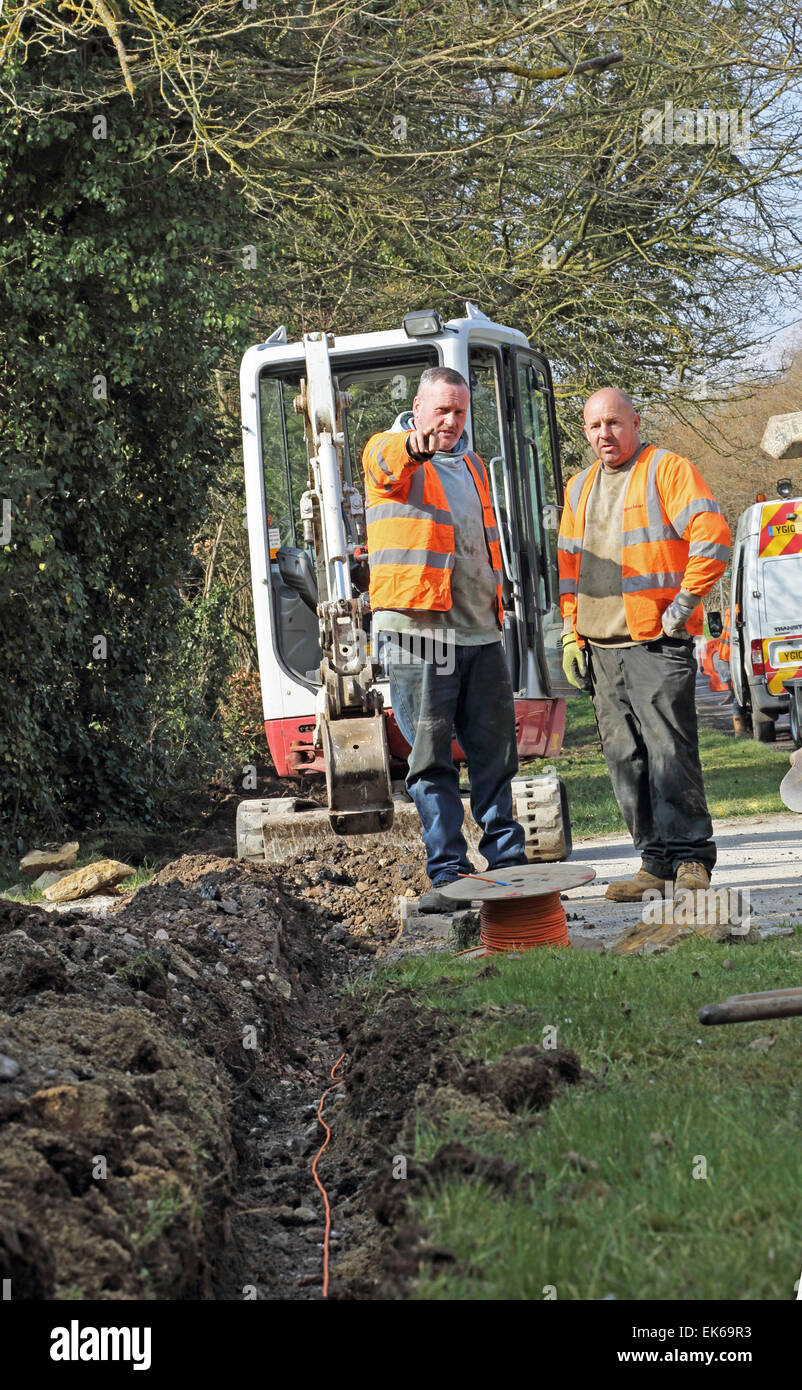 Arbeiter verwenden eine Minibagger, um neue high-Speed Breitband Glasfaserkabel in einem ländlichen Dorf in Oxfordshire installieren Stockfoto