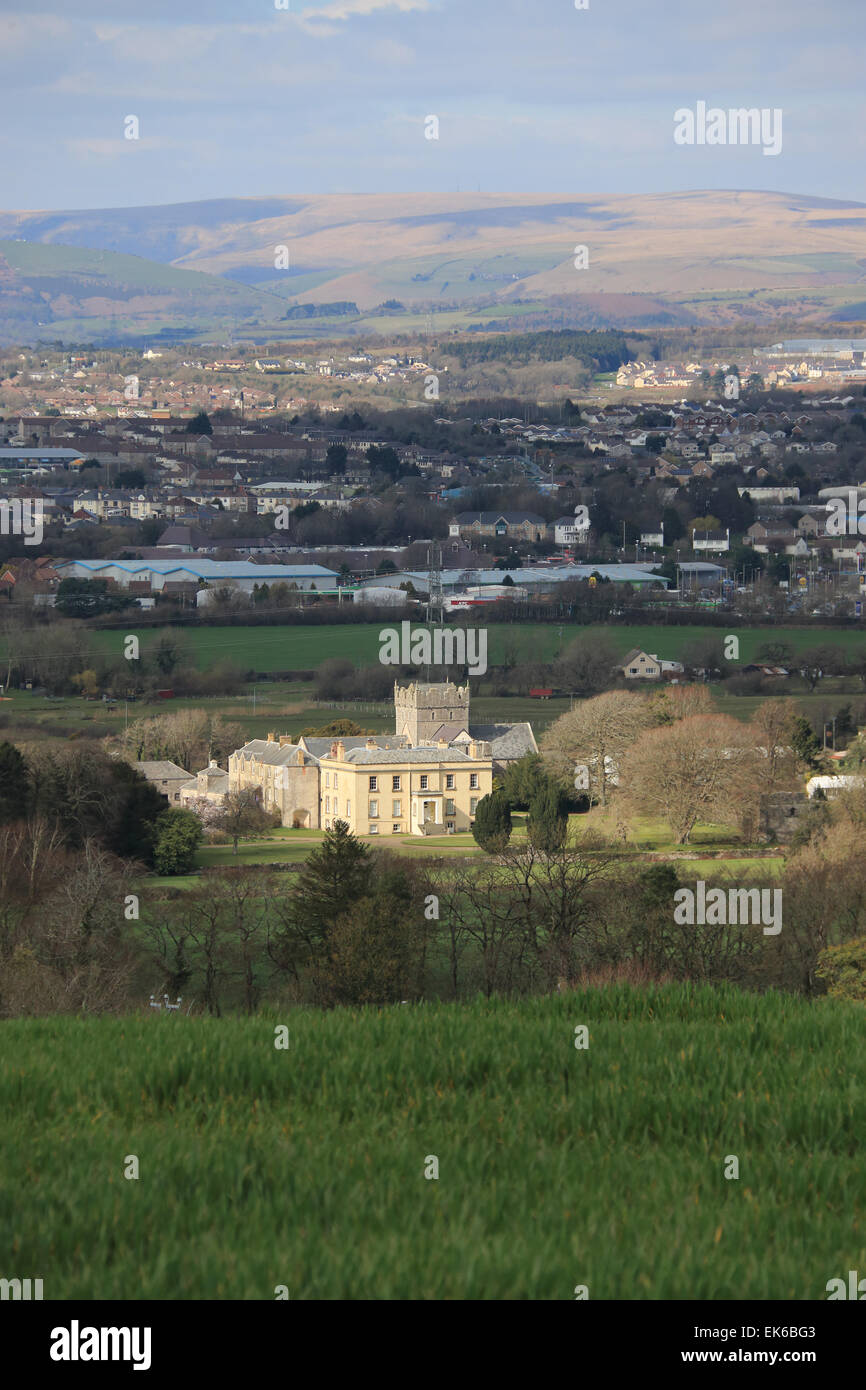 Ewenny Priorat mit Bridgend Stadt hinter Stockfoto