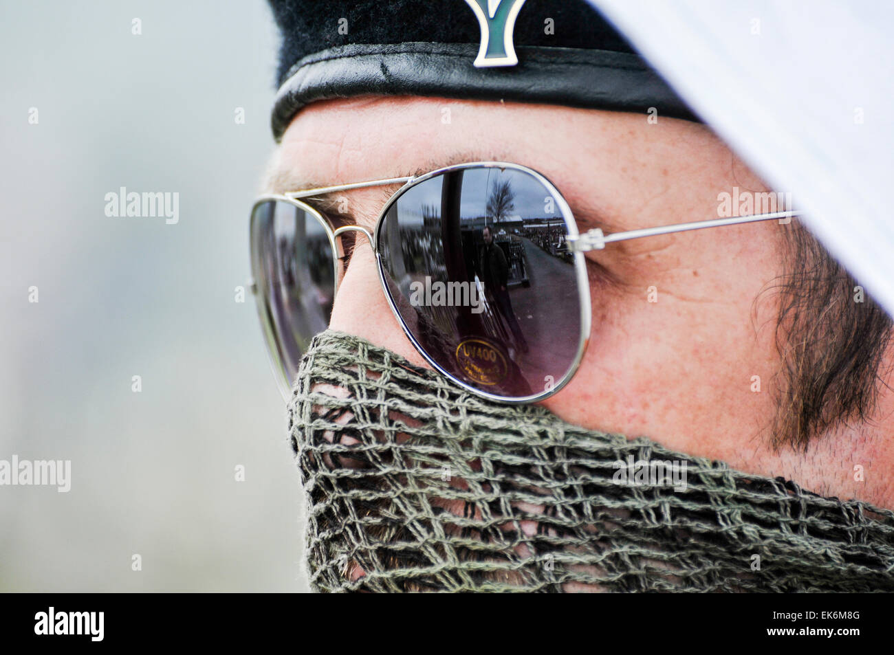 Ein maskierter Mann, der ein Gelege über seinen Mund, Sonnenbrille und ein schwarzes Barett ist Teil eines irischen Republikaner gedenken Stockfoto