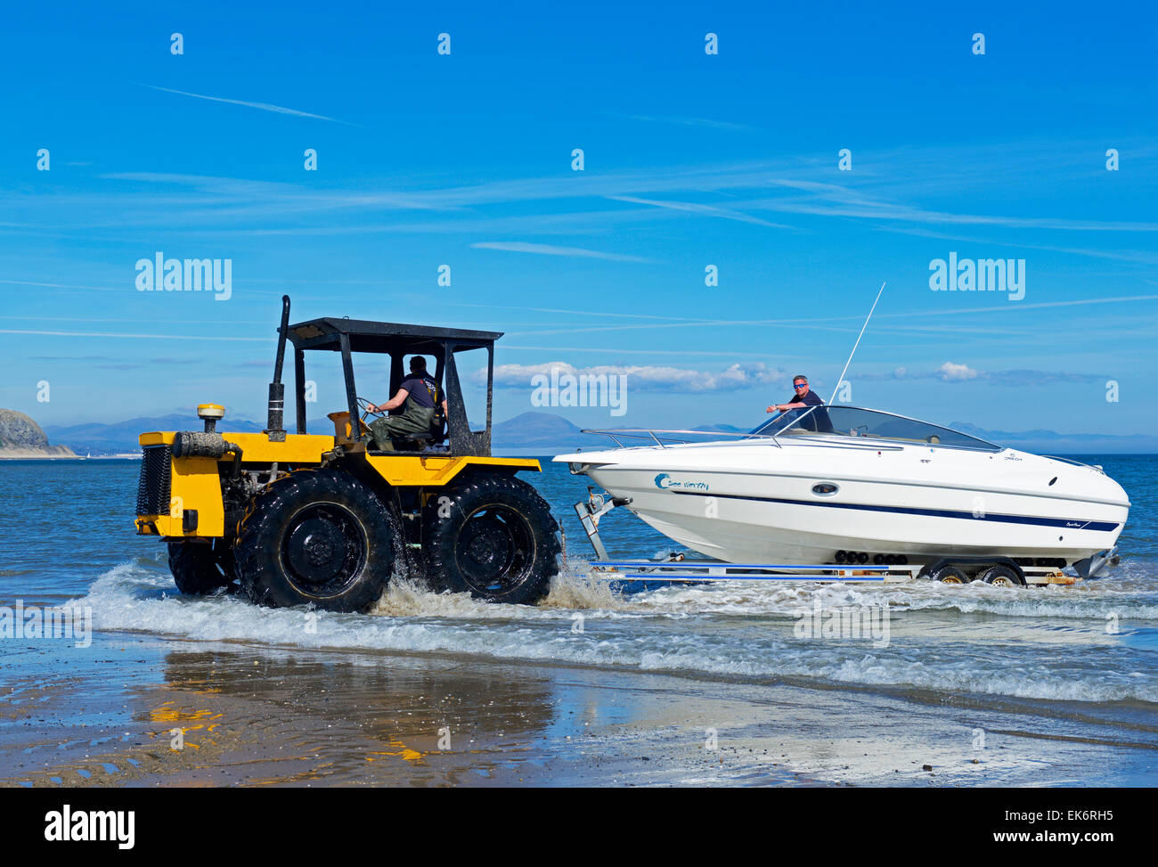 Traktor Abschleppen Schnellboot auf Anhänger aus dem Meer, Abersoch, North Wales, UK Stockfoto