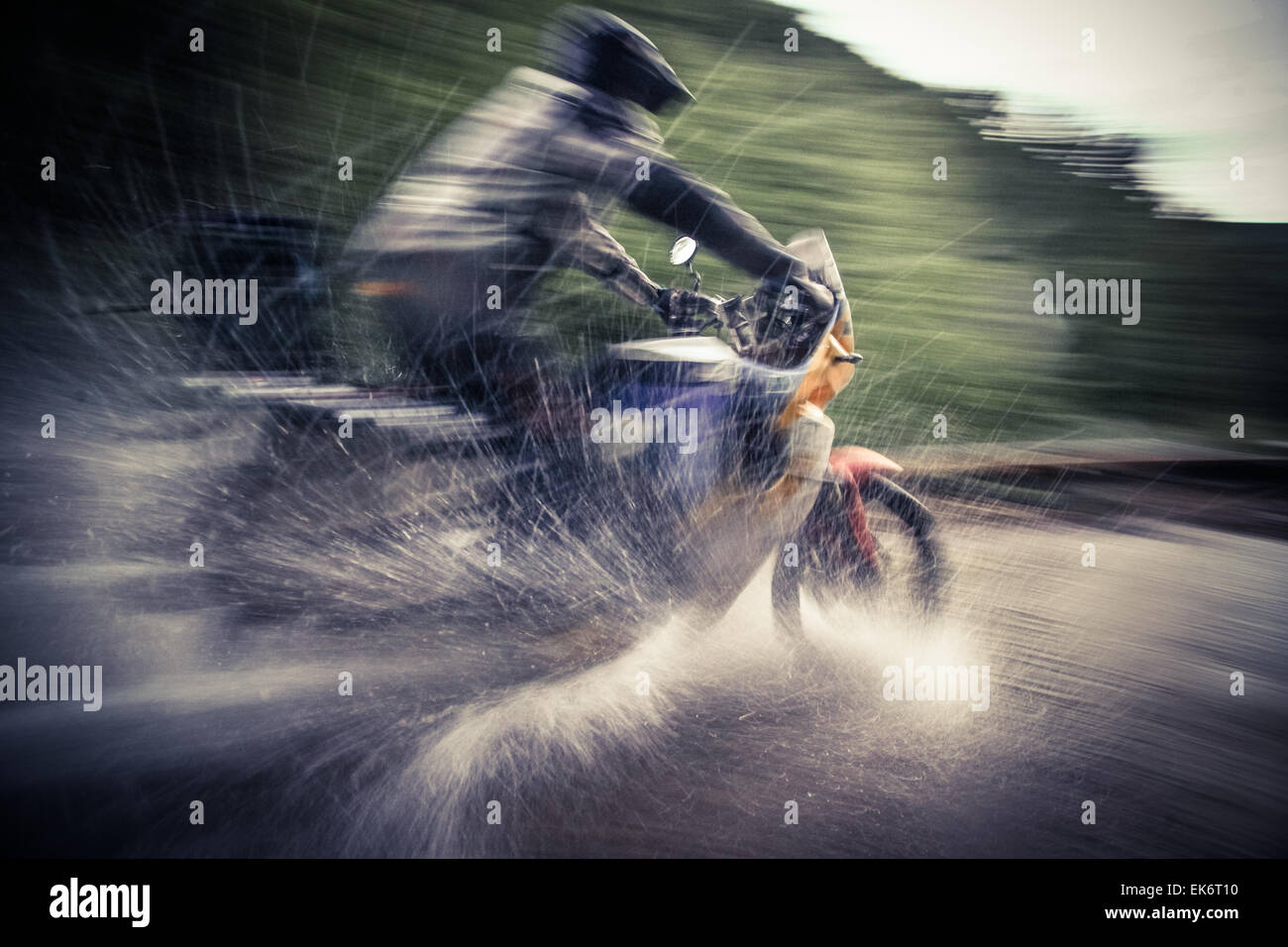 Farbe, Schuss, Bewegungsunschärfe, der ein Motorradfahrer einen Fluss überquert. Stockfoto