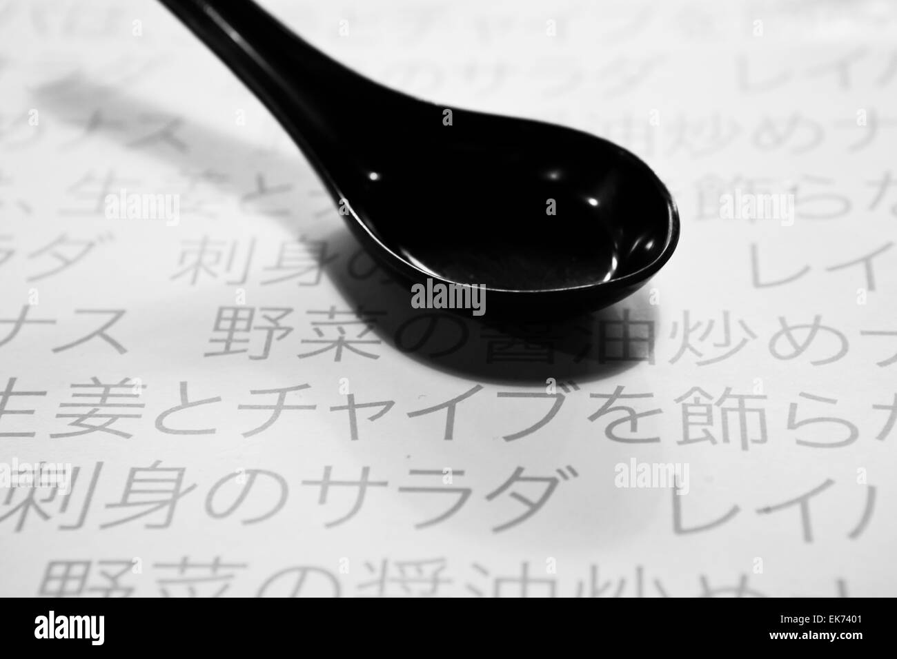 Eine schwarze Löffel über Papier Tischset eines Restaurants mit Japanesse schreiben Stockfoto