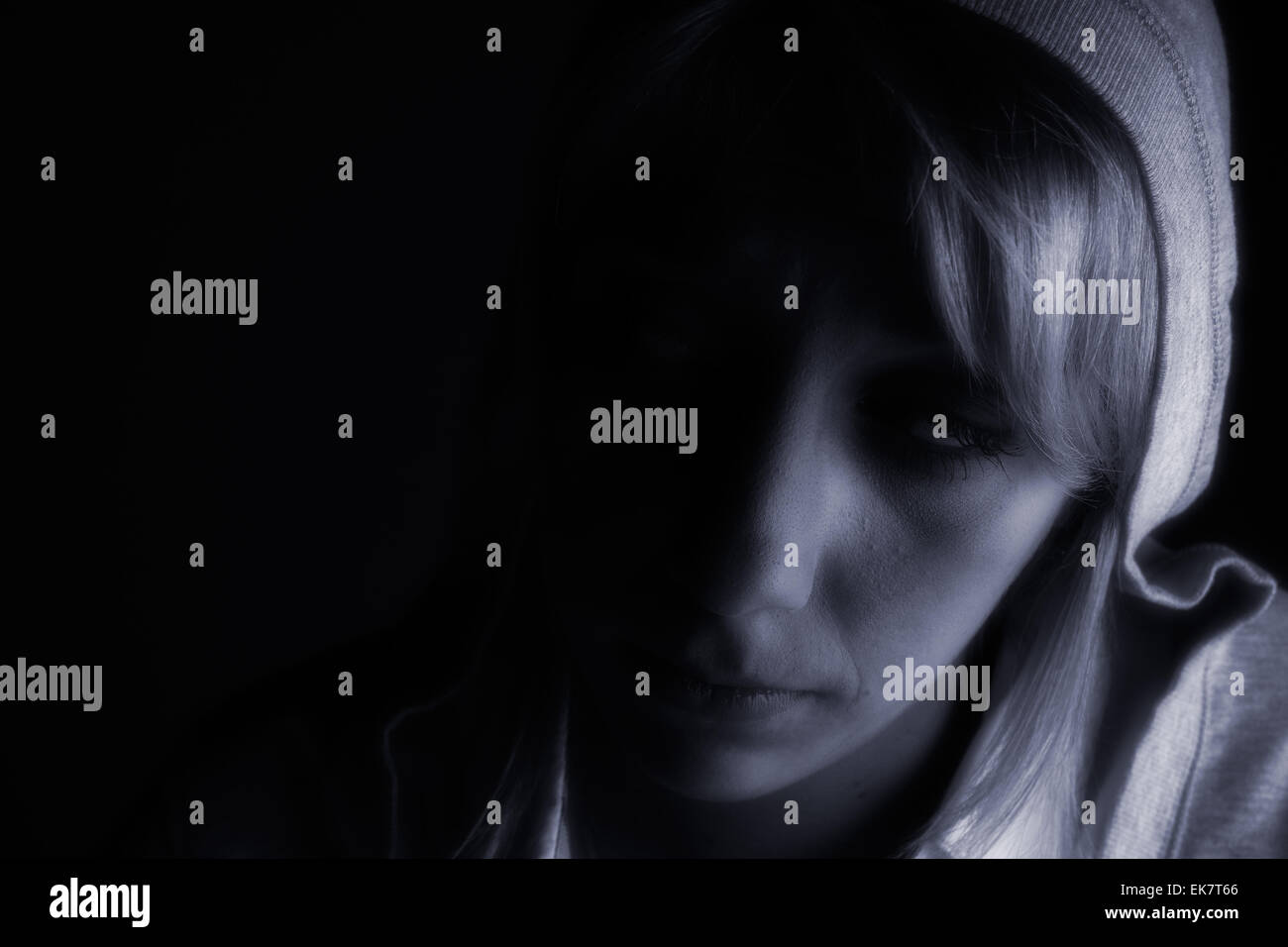 Studio-Porträt eines langen blonden Mädchens im Dunkeln Stockfoto