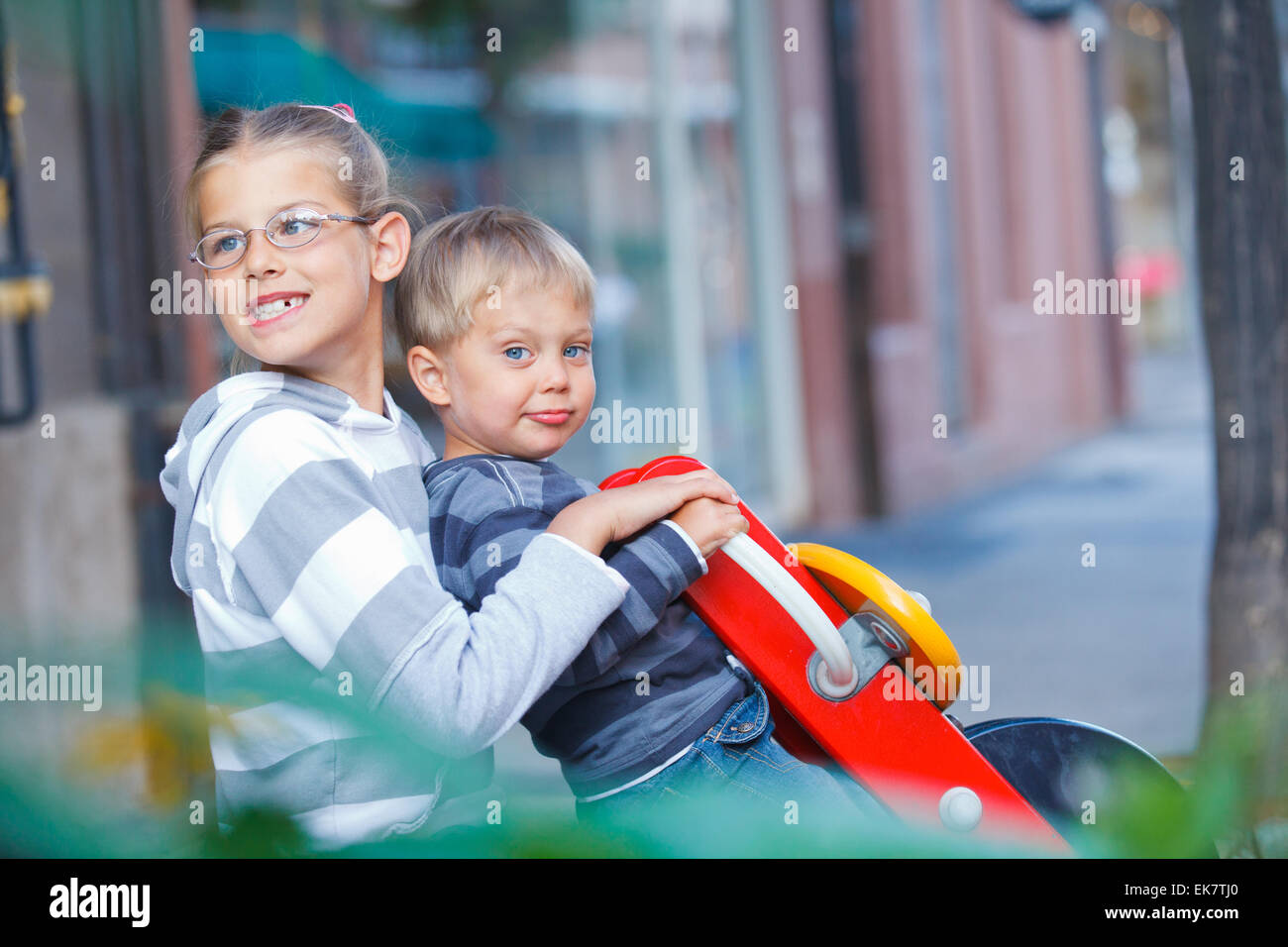 Glückliche Kinder reiten auf der Schaukel auf dem Spielplatz Stockfoto