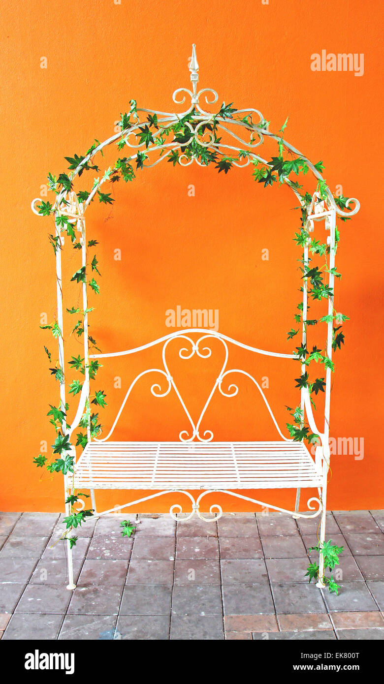 weiße romantische Vintage Sessel mit orange Wand Stockfoto